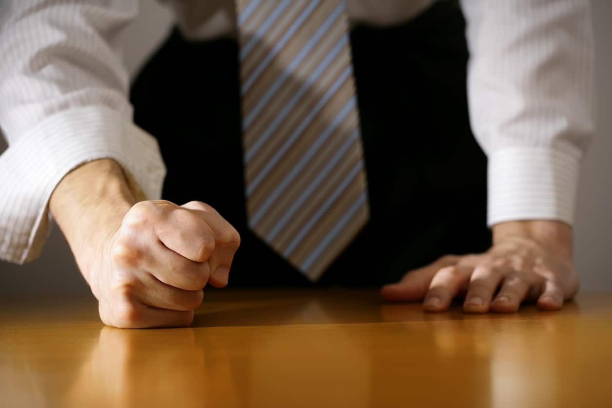 businessman hitting the table with clenched fist.